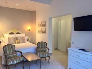 - une chambre avec un lit, une table et des chaises dans l'établissement Villa La Clarté, à Cavalaire-sur-Mer