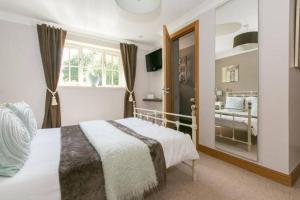 a bedroom with a large bed and a mirror at Annora House in Berkswell