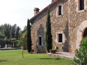 Camallera的住宿－Costa Brava Apartment Casa Isabelle，享有带庭院的石头建筑的外部景色