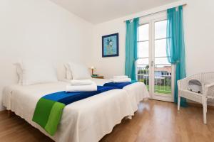 a bedroom with two beds and a large window at Madame Vacances Les Villas de Fontenelles in LʼAiguillon-sur-Vie +18 photos