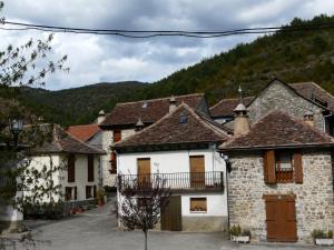 un grupo de casas en un pueblo con una montaña en Casa Rural Quilero en Fago