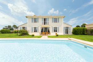 una gran piscina frente a una casa en Madame Vacances Les Villas de Fontenelles, en LʼAiguillon-sur-Vie