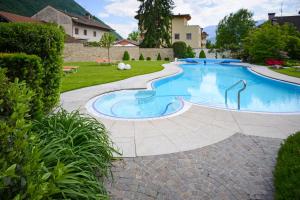 een zwembad in het midden van een tuin bij Hotel Garni Günther in Postal