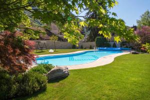 una piscina en un patio con césped y árboles en Hotel Garni Günther, en Postal