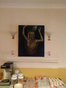 a painting on the wall above a table with food at Chadwick House Hotel in Macclesfield