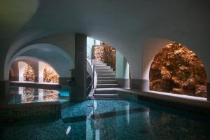 a building with a swimming pool with stairs and water at Cappuccini Resort in Cologne