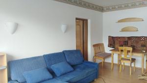 un salon avec un canapé bleu et une table dans l'établissement Happy Stay Apartment, à Bad Mitterndorf 32 autres photos