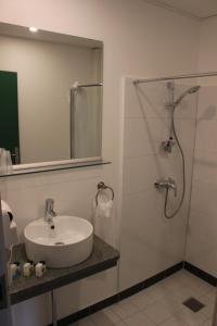 a bathroom with a sink, toilet and shower at Hotel Hirtshals in Hirtshals