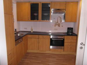 a kitchen with wooden cabinets and a sink and a stove at Ferienwohnung Kreischer in Weidenberg