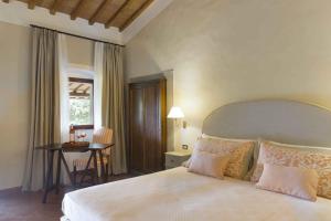 a bedroom with a large bed and a large window at Tenuta di Artimino member of Meliá Collection in Artimino