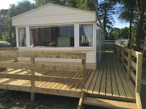 a house on a wooden deck with a window at 35 Glenfinart Park in Dunoon