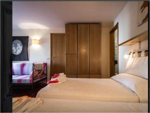 una habitación de hotel con dos camas y una silla en Le Camerelle 83, en Capri