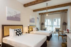 a hotel room with two beds and a table at Beach Walk Boutique Jumeirah in Dubai