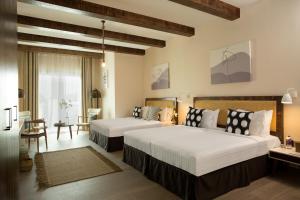 a bedroom with two beds and a table and chairs at Beach Walk Boutique Jumeirah in Dubai