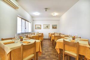 a room with tables and chairs in a restaurant at Albergo Natalina in Finale Ligure