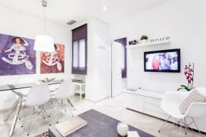 a white living room with a dining table and white chairs at Serrano Apartment by Flatsweethome in Madrid