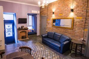 Una sala de estar con un sofá y una pared de ladrillos. en Sofia Apartment in old Tbilisi, en Tiflis