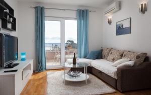 uma sala de estar com um sofá e uma mesa de vidro em Relax Makarska em Makarska