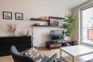 ein Wohnzimmer mit Fernseher und Tisch in der Unterkunft The SUNNY PRAGUE APPARTMENT&Garage in Prag