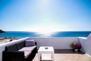 a balcony with a couch and a table and the ocean at Paradise Beach Resort in Paradise Beach
