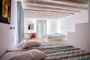 two beds in a room with white walls at Paradise Beach Resort in Paradise Beach