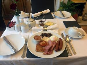 a table with a plate of breakfast food on it at Crickleigh House in Llandudno