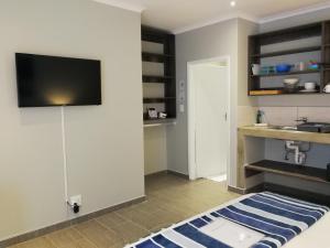 a living room with a flat screen tv on a wall at Sea Wind Self Catering Cottages in Swakopmund