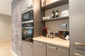 a kitchen with a counter with a coffee maker and a microwave at Montaber Apartments - Sagrada Familia in Barcelona