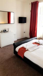 1 dormitorio con 1 cama con cortina roja en The Star Inn en Nottingham