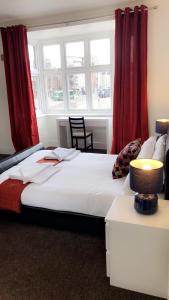a bedroom with a large bed with red curtains at The Star Inn in Nottingham