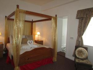 a bedroom with a bed and a canopy at Holliers Hotel in Shanklin