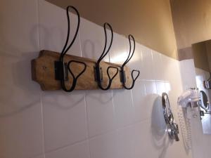 uma casa de banho com três pares de óculos pendurados na parede em Hôtel-Restaurant "Chez Carrière" em Aigues-Mortes