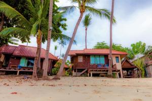 a house on the beach with palm trees at Bangrak Pier Bungalow in Bangrak Beach