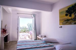 a bedroom with a bed and a door to a balcony at Paradise Beach Resort in Paradise Beach