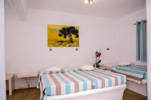 a bedroom with two beds and a tree on the wall at Paradise Beach Resort in Paradise Beach