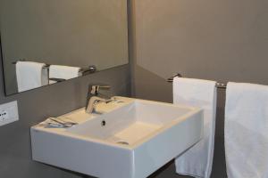 a bathroom with a sink and a mirror and towels at Hotel Villa Maria in Sirmione