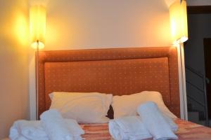フンシャルにあるCentral Suite in Funchal 1Nのベッド1台(タオル2枚、ランプ2つ付)