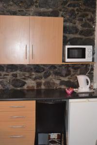 フンシャルにあるCentral Suite in Funchal 1Nのキッチン(電子レンジ、椅子付きのカウンター付)