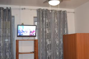 a tv sitting in a room with curtains at Central Suite in Funchal 1N in Funchal