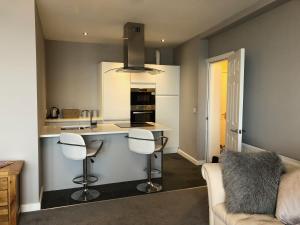 a kitchen with a counter and stools in a room at Morecambe sea view apartment 203 in Morecambe