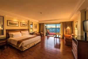 a hotel room with a bed and a living room at Grand Hotel Gozo in Għajnsielem