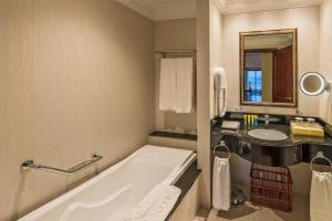 a bathroom with a tub and a sink at Grand Hotel Gozo in Għajnsielem