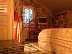 1 dormitorio con cama, ventana y TV en chalet des petits loups, en Chamonix-Mont-Blanc
