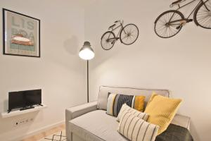 リスボンにあるLisbon Menta Apartmentのリビングルーム(ソファ付)、壁に自転車が備わります。