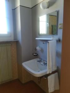 y baño con lavabo y espejo. en Hotel Roen Ruffrè-Mendola en Mendola