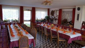 uma sala de jantar com mesas longas e cadeiras em Hotel Roen Ruffrè-Mendola em Mendola