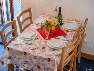 una mesa con platos y copas y una botella de vino en Il Baluardo Sea View Apartment on the Cliff, en Manarola