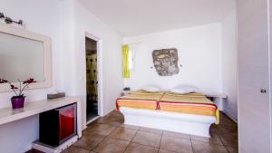 a white bedroom with a bed and a fireplace at Paradise Beach Resort in Paradise Beach