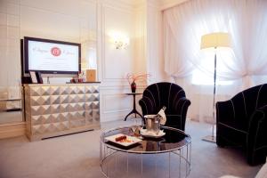 a living room with two chairs and a table and a television at Opera Hotel - The Leading Hotels of the World in Kyiv