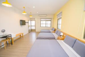 a hospital room with four beds and a television at Colorful B&B in Xiaoliuqiu